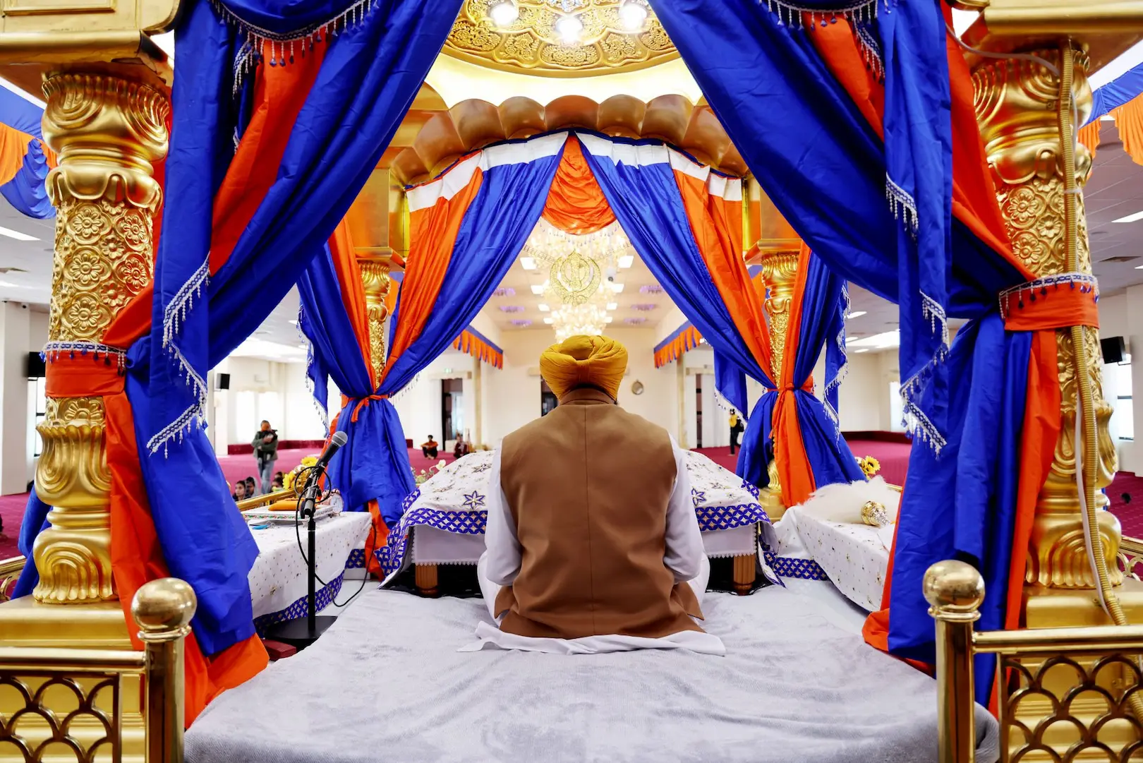 O granthi com o Guru Granth Sahib no gurdwara.